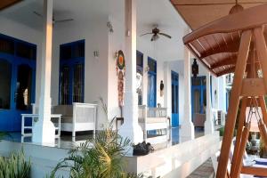 a porch of a house with blue doors at Belvilla Tranquil Oasis Lovina BeachNearKrisna Funtasticland in Lovina