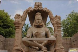 a statue of a deity sitting in a wall at Osho's Organic Resort Hampi in Hampi