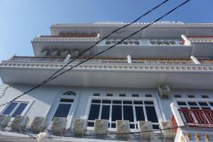 un edificio blanco con sillas a un lado en OYO 93773 Pondok Bintang en Kendari