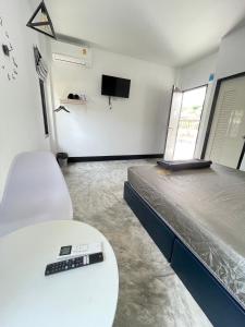 una camera con un letto con telecomando su un tavolo di บ้านพักสุดซอย a Ban Rai