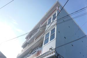 a white building with power lines in front of it at OYO 93773 Pondok Bintang in Kendari