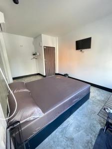 un grande letto in una camera con TV a parete di บ้านพักสุดซอย a Ban Rai