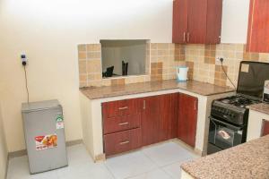 een keuken met houten kasten en een zwarte kat in een spiegel bij Nyali Sea View 4 Beds Apartment With Pool in Mombasa