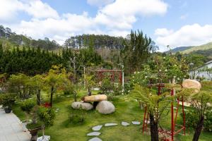 einen Garten mit Felsen, Pflanzen und Bäumen in der Unterkunft WHITE HOUSE in Ấp Ðinh An (1)
