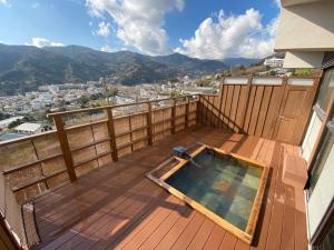 a balcony with a plunge pool on a wooden deck at Ryokan -Suikoen- by Tranova in Yugawara
