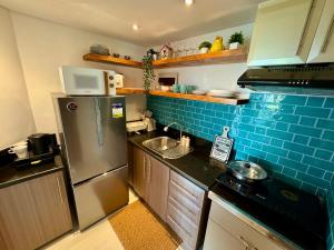 a kitchen with a refrigerator and a sink at 2br Golfcourse view near airport in Manila