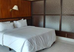 a bedroom with a large white bed in a room at Khas Parapat in Parapat