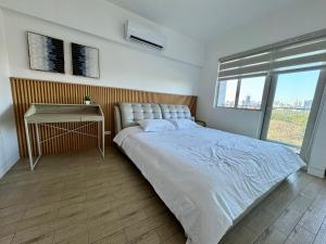 a bedroom with a large bed and a table at 2br Golfcourse view near airport in Manila