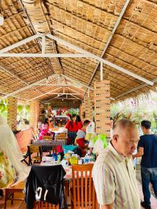 eine Gruppe von Personen, die in einem Restaurant an Tischen sitzen in der Unterkunft WHITE HOUSE in Ấp Ðinh An (1)