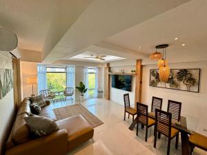 a living room with a couch and a dining room at 2br Golfcourse view near airport in Manila
