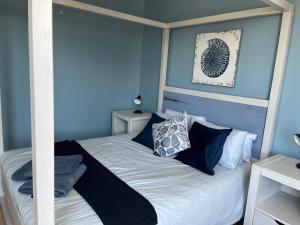a bedroom with a bed with blue walls at SM @ C - Seesonnet 13 in Freeland Park +9 photos