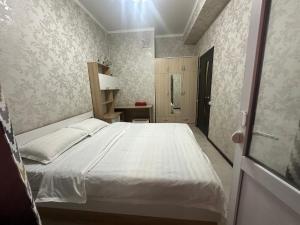 een slaapkamer met een groot wit bed in een kamer bij Center Cozy Apartment in Bisjkek
