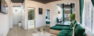 a living room with a green couch and a bathroom at TAN de LUX in Mamaia Sat/Năvodari