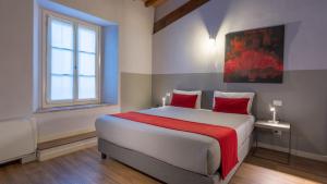 a bedroom with a large bed with red pillows at Hotel Cortaccia Sanvitale in Sala Baganza