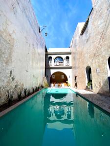 uma piscina num edifício antigo com água azul em Hotel Plaza D Armas em Querétaro