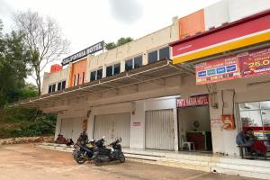 a motorcycle parked in front of a building at OYO 93781 Hotel California 2 in Bagam