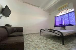 a living room with a couch and a window at OYO 93781 Hotel California 2 in Bagam