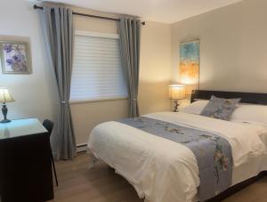 Un dormitorio con una cama grande y una ventana en Coquitlam center, 2 bedroom suite, walking to skytrain en Port Coquitlam