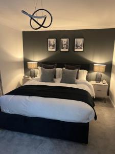 1 dormitorio con 1 cama grande y pared negra en Glenshellach Apartment Oban en Oban