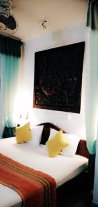 a bedroom with a bed with two yellow pillows at Lihini Scandic Eco Village in Habarana
