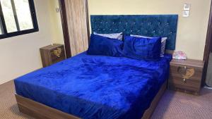 a bedroom with a blue bed with a blue comforter at furnished apartments for rent in Irbid