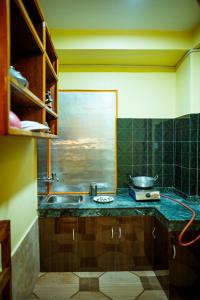 una cucina con lavandino e un dipinto sul muro di Paradise Boutique Hotel a Pokhara