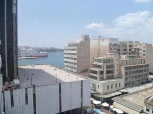 una vista de una ciudad con edificios y una masa de agua en Triton Hotel Piraeus, en Pireo