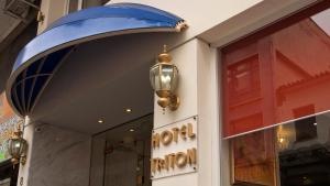 a door to a store with a blue canopy and a light at Triton Hotel Piraeus in Piraeus
