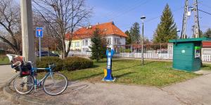 a bike is parked next to a parking meter at Napvirág - Közel mindenhez in Balatonakarattya