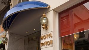 ピレウスにあるトリトン ホテル ピレウスの青い日よけと窓のある店舗