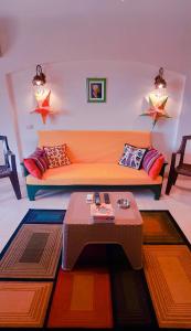 La Hacienda ras sedr chalet في رأس سدر: غرفة معيشة مع أريكة برتقالية وطاولة