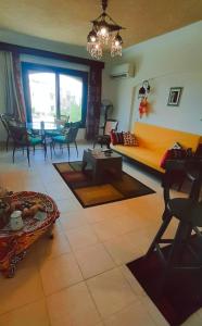 La Hacienda ras sedr chalet في رأس سدر: غرفة معيشة مع أريكة وطاولة