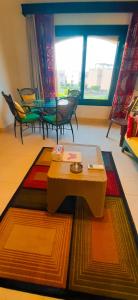 ein Wohnzimmer mit einem Tisch, Stühlen und einem Fenster in der Unterkunft La Hacienda ras sedr chalet in Ras Sudr