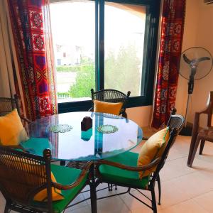 een eettafel met stoelen en een raam bij La Hacienda ras sedr chalet in Ras Sedr