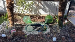 a garden with green glass birds in a yard at Camere Aeroporto Cagliari Elmas in Elmas