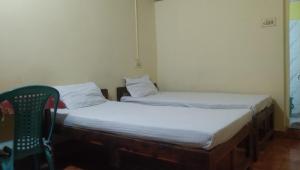 2 camas individuales en una habitación con silla en Laxmi Guest House (Arambol Beach) en Arambol