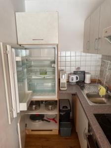 una cucina con frigorifero vuoto e lavandino di FeWo Bergzeit-Nagelfluh direkt am Naturpark a Blaichach