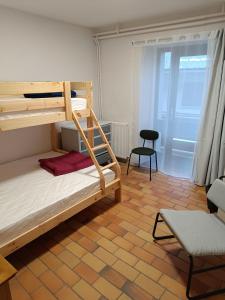 a bedroom with two bunk beds and a chair at La Mansio de Bons in Les Deux Alpes