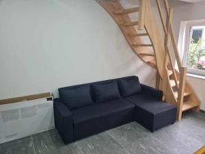 ein blaues Sofa in einem Zimmer mit einer Treppe in der Unterkunft Les gîtes du Ravel in Soignies