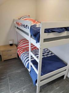 two bunk beds in a small room with a bed at Les gîtes du Ravel in Soignies