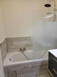 eine Badewanne mit einem Wasserhahn im Bad in der Unterkunft Les gîtes du Ravel in Soignies