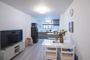 a kitchen and living room with a table and a tv at - UMI-Haven 福島 - 隣駅5LDK戸建 in Osaka
