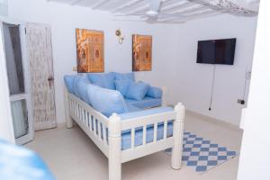 a living room with a blue couch and a tv at Malindi Palm Villa- Harbour Key Cottages, Villa 16, Silver Sands Road in Malindi