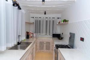 a kitchen with a sink and a counter top at Malindi Palm Villa- Harbour Key Cottages, Villa 16, Silver Sands Road in Malindi