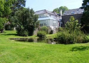 una casa con un estanque en el patio en Buckland House en Slapton