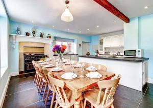 a dining room with a long wooden table and chairs at Buckland House in Slapton