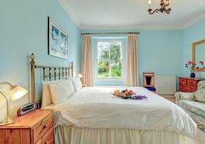 a bedroom with a bed with a plate of fruit on it at Buckland House in Slapton