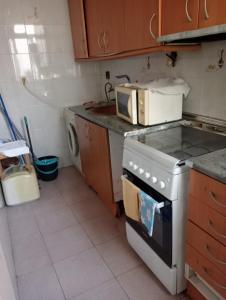a kitchen with a stove and a microwave at Barcelona Appartment in Santa Coloma de Gramanet