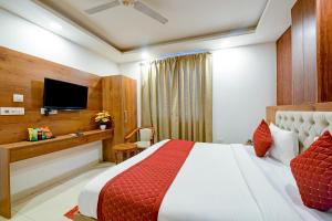 a hotel room with a bed and a tv at Hotel Grand Qubic Near Delhi Airport in New Delhi