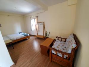 a living room with a couch and a bed at Santoshi Guest House and Yoga Center in Pokhara
